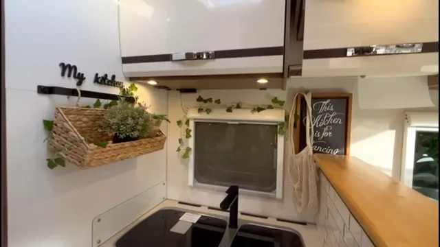 Cocina con encimera de madera, fregadero y armarios superiores