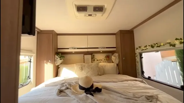 Dormitorio trasero con cama, ventanas a ambos lados y armarios superiores