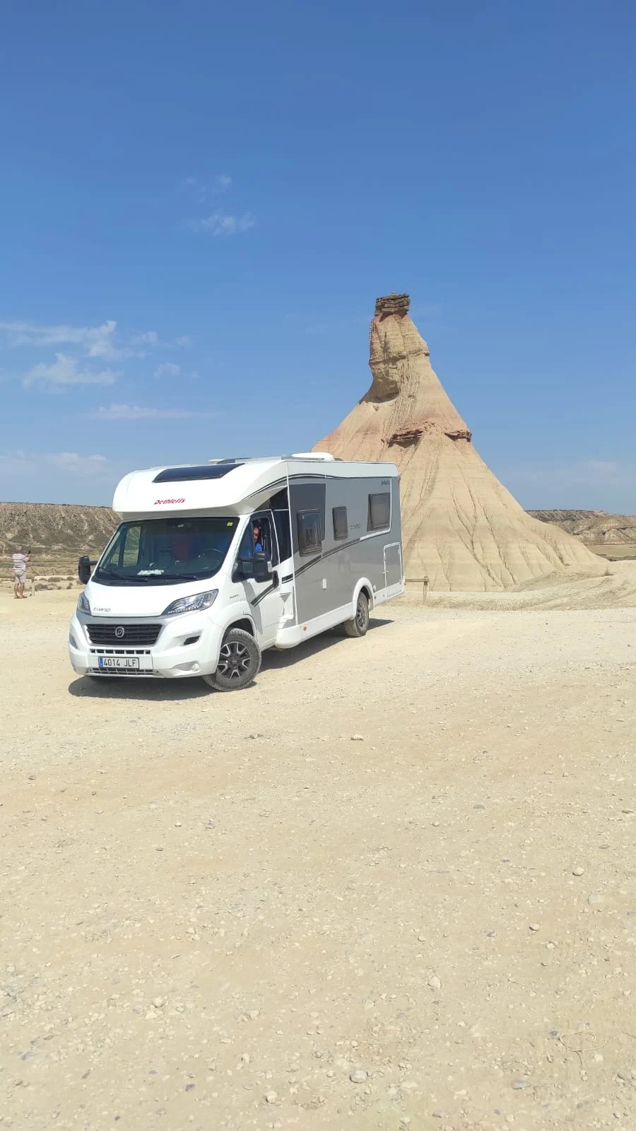 La autocaravana de Indómito Road aparcada en un paisaje árido de roca, bajo un cielo despejado